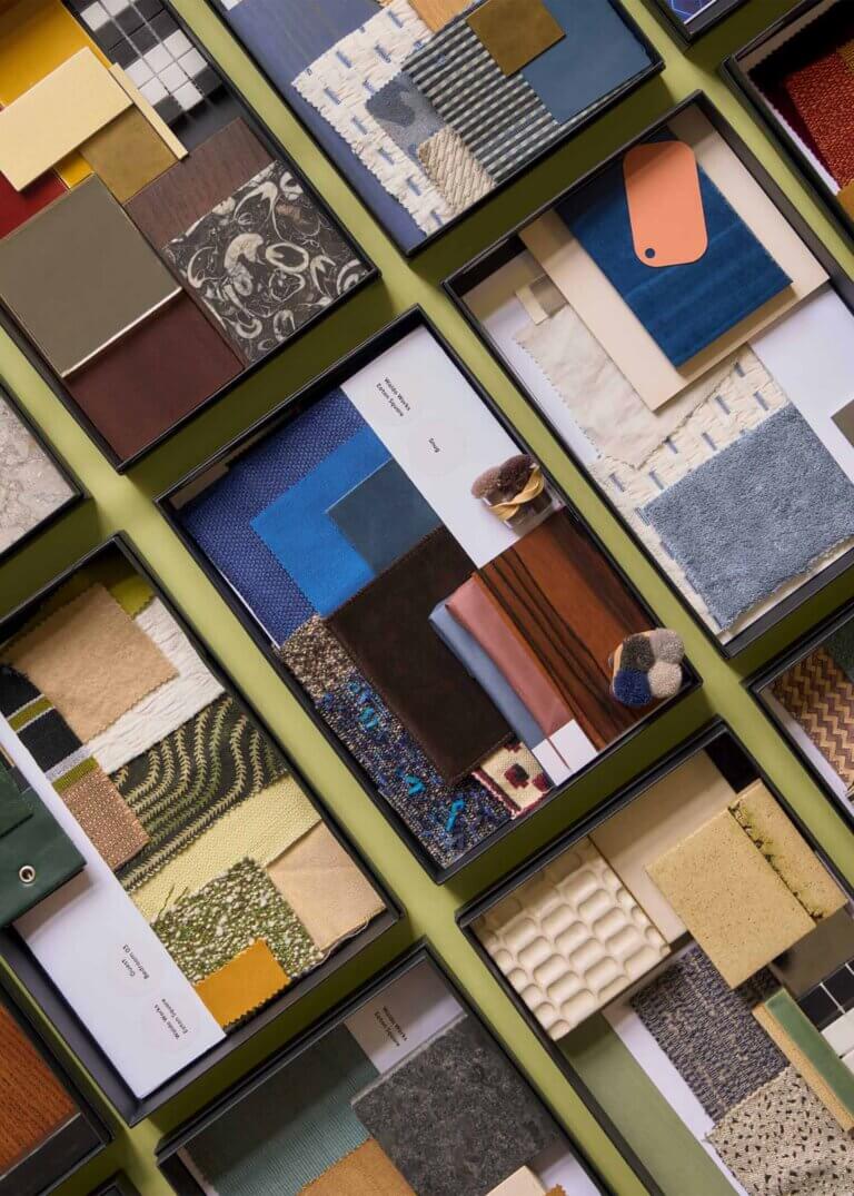 Branding and identity image for Waldo Studio featuring curated boxes of architectural and interior finish samples, including textiles, wood veneers, stone, and material palettes arranged in a refined studio composition.